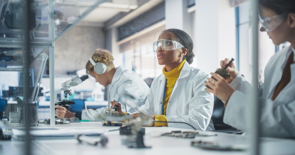 Modern Science Research Laboratory in University: Diverse Young Scientists in Coats Using Microscope