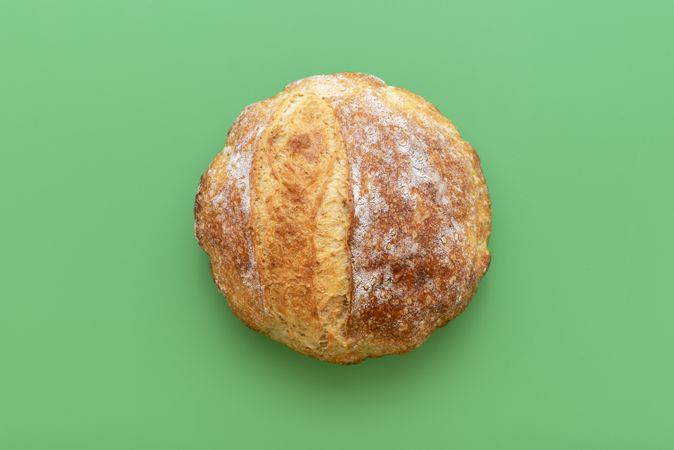 Loaf of bread on a green table, above view