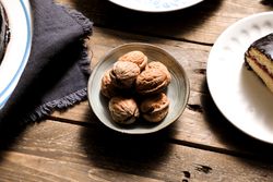 Nuts in bowl cake and napkin on table