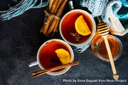 Two tea cups with lemon and star anise and cinnamon stick on red napkin 4d8PRa