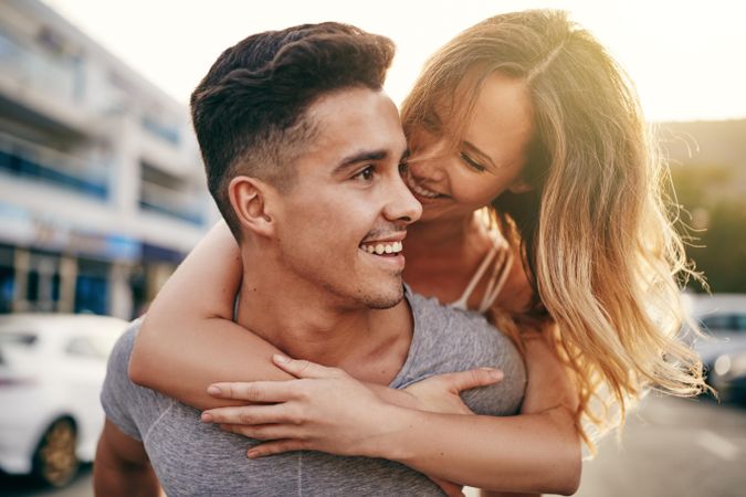 Happy woman embracing her boyfriend from the back