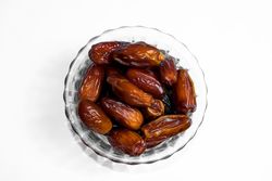 Dates fruits in a bowl glass on isolated studio background