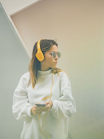 Trendy young woman with headphones and smartphone
