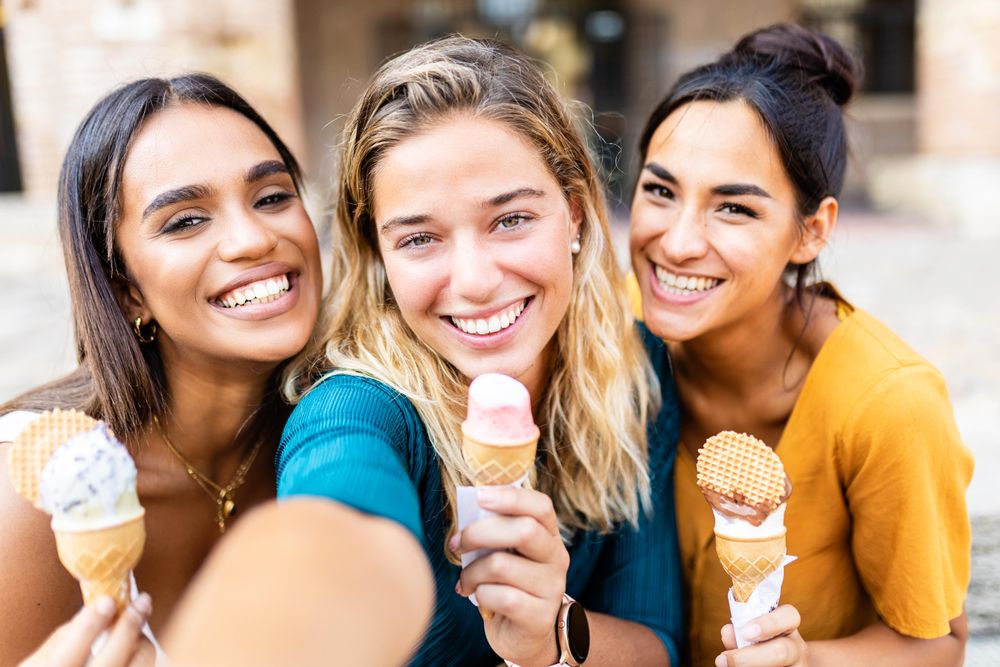 Selfie of three young women eating ice cream