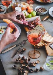 Charcuterie, with wine and snacks, man with prosciutto and melon with hazelnuts