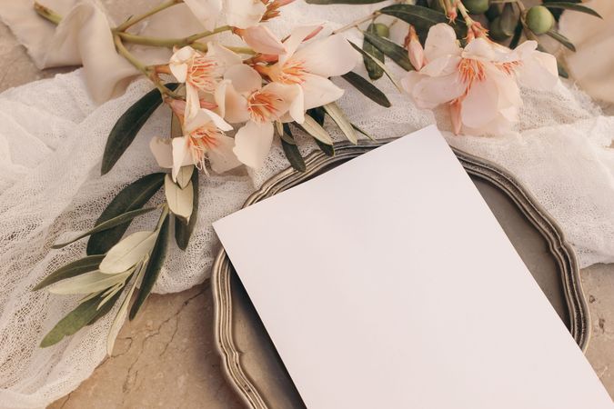 Closeup of blank greeting card, invitation mockup on vintage silver plate.