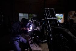 Unrecognizable mechanic repairing motorbike in garage