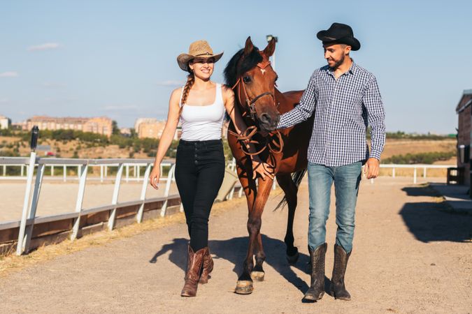 Friends walking with a horse in an equestrian center