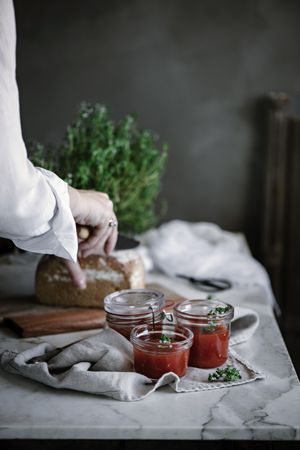 Fresh bread on napkin near tomatoes jam