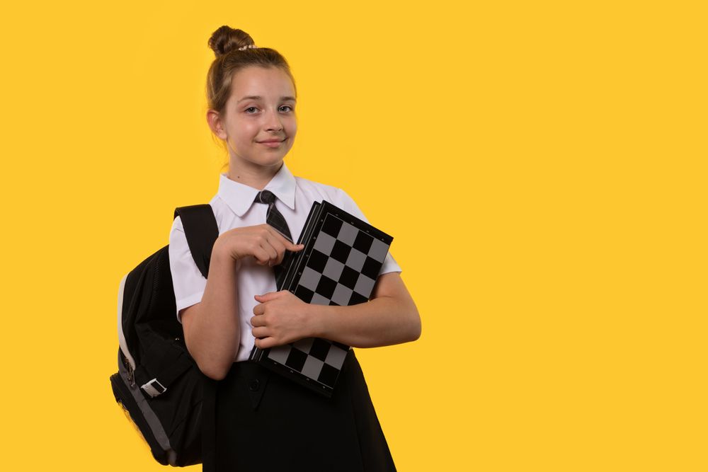 Schoolgirl confidently points at chessboard