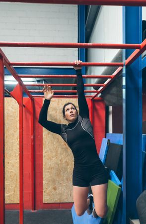 Sportswoman exercising on monkey bars