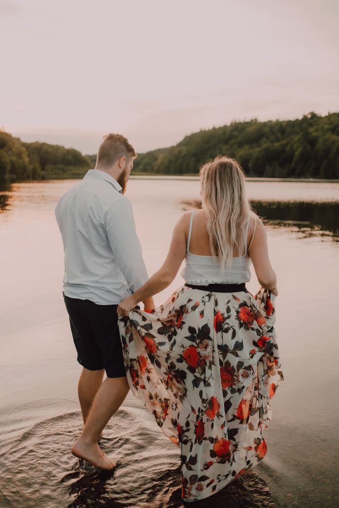 Loving couple hugging while standing ankle deep in water on beach