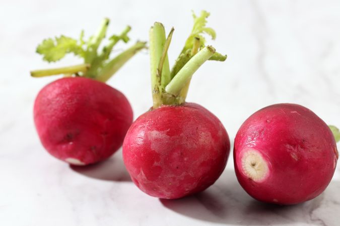 Three Red Raddish on Marble Background