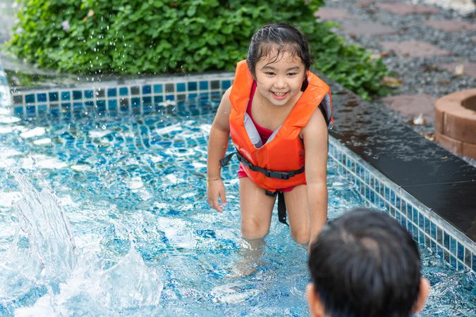 Asian children playing in the swimming pool together