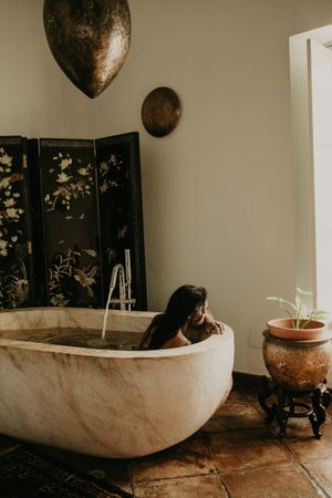 Melancholic Woman sitting and washing in bath