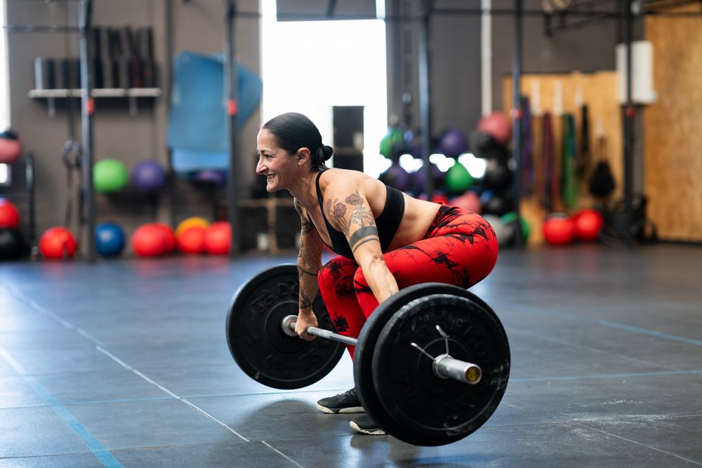 Tattooed fit woman deadlifting