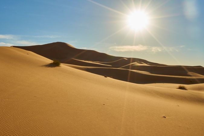 Sand dunes and blue sky with sun