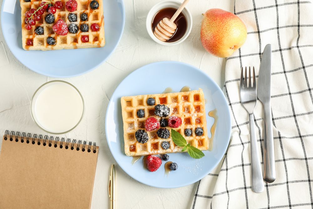 Composition of breakfast with belgian waffles, top view