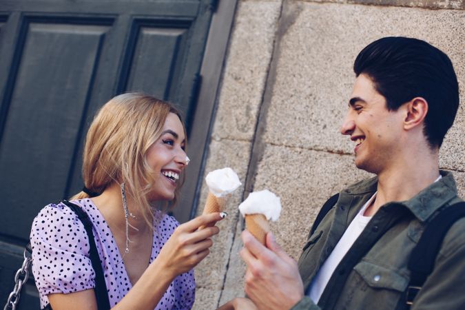 Happy couple feeding each other by ice cream
