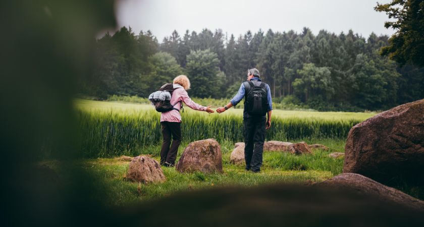 Woman reaches for her partner's hand while overlooking trees