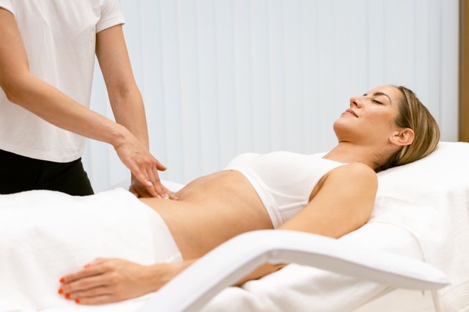 Side view of woman having her torso massaged
