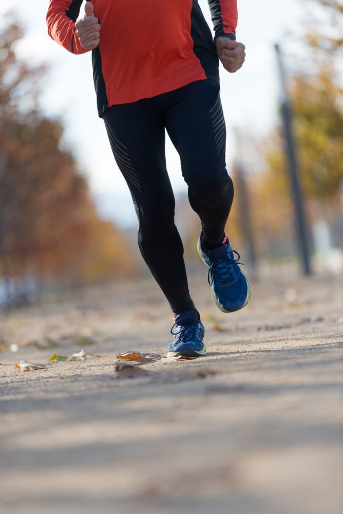 Legs of male running in park outside