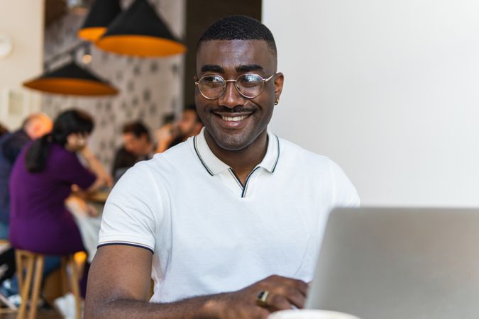 Black man using laptop at table in cafe