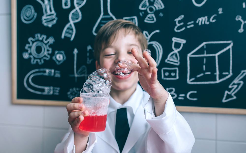 Happy child holding glass with soap foam