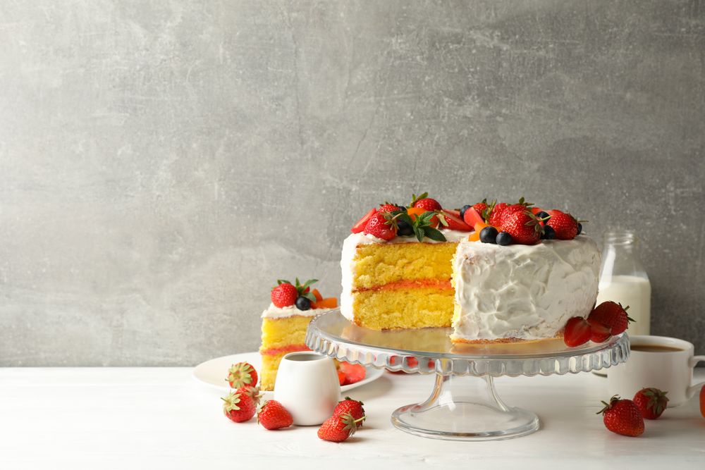 Composition with delicious berry cream cake against gray background. Tasty dessert