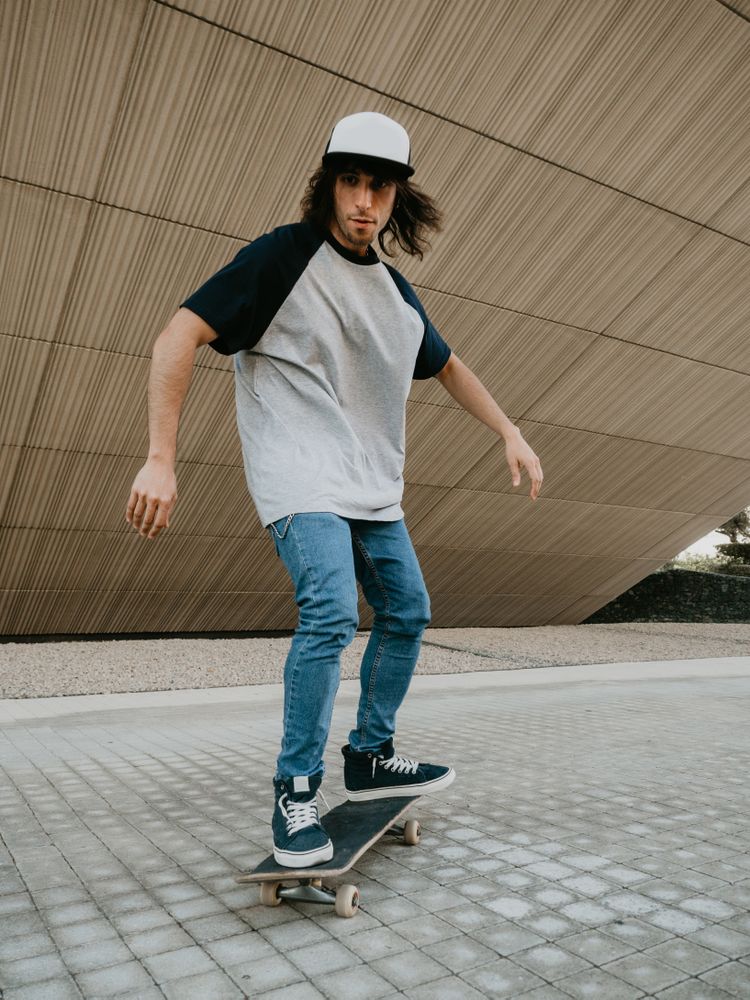 Sportive man riding skate on road along sloping wall