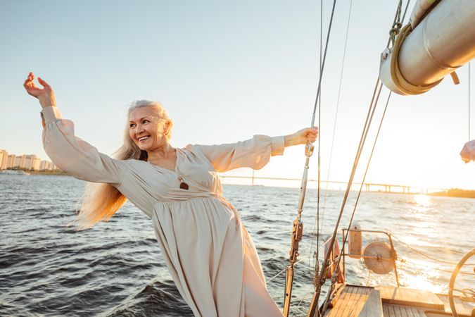 Mature happy woman with long gray hair on a sailboat
