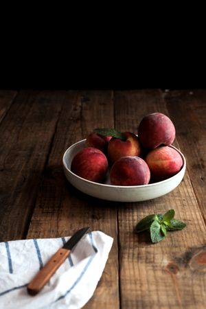 Tasty ripe peaches in plate on table