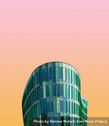 Green building against a gradient pink and orange sky 42dJe0