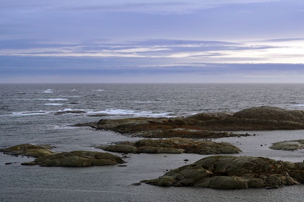 Rocky seashore and dark wavy sea in dusk