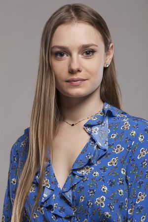 Blonde woman with floral shirt posing in studio