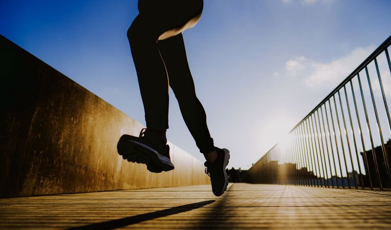 Woman running on street in sunny day