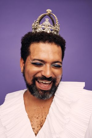 Man with beard wearing makeup and crown