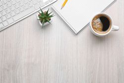 Cup of Coffee with Office Tools on Light Wooden Background