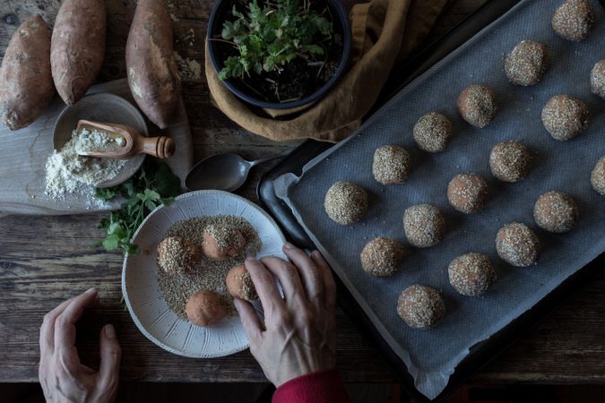 Person rolling in breadcrumbs sweet potatoes