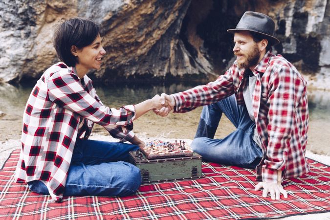 Casual couple playing chess on shore