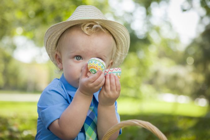 Cute Little Boy Enjoying His Easter Eggs Outside in Park