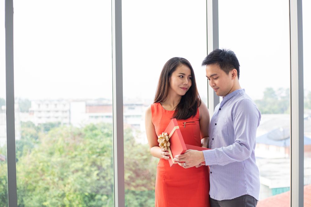 Asian couple opening box and looking surprise