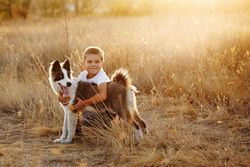 Cute boy with dog on a leash in nature with space for text