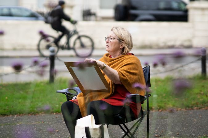 Older woman looking from drawing board in park