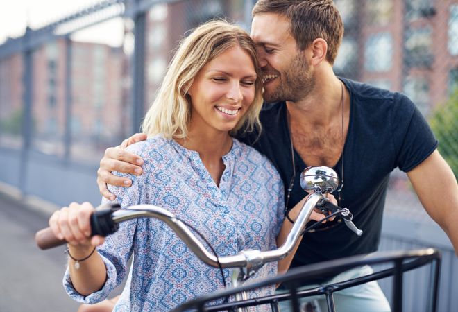 Cute couple smiling with their eyes closed on bicycles