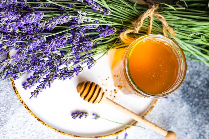 Top view of pot of honey with bunch of lavender with space for text