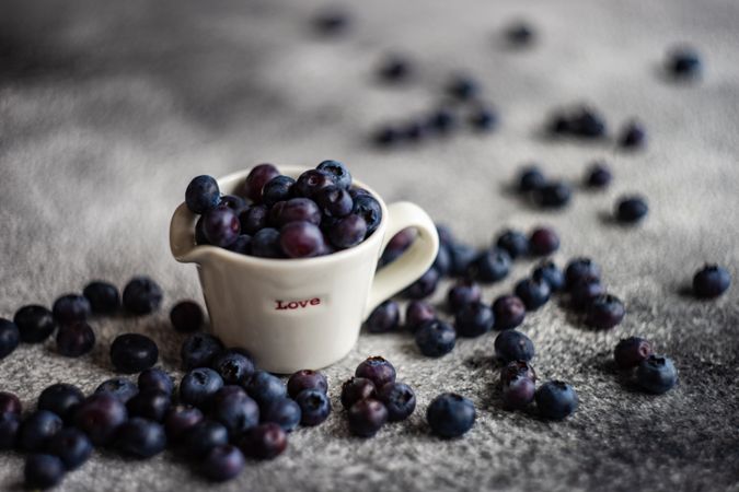 Blueberries around "love" ceramic pouring cup