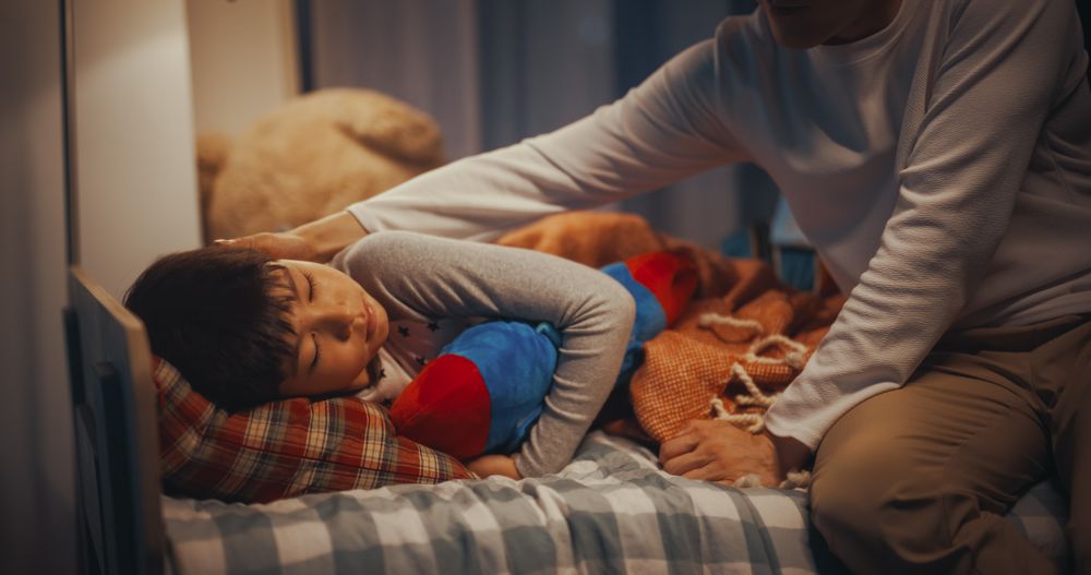 Korean Parent Tucking Little Boy in Blanket, Making Sure He is Warm and Comfortable at Night