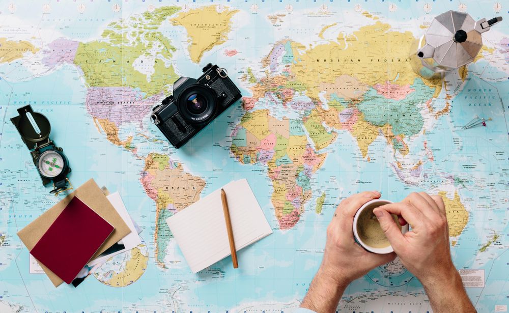 Dark camera and paper on world map