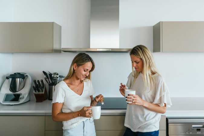 Women with coffee chatting in kitchen